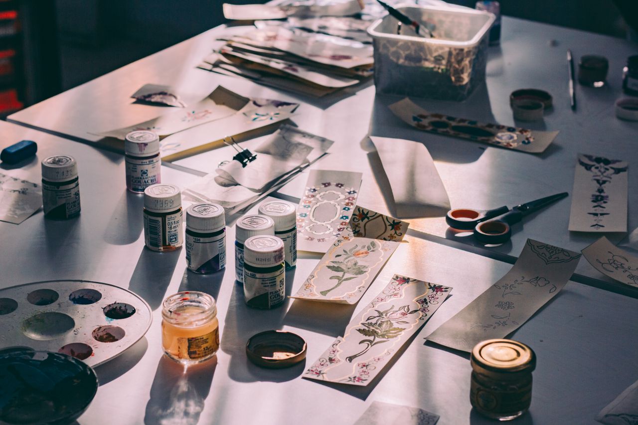 Artist workspace with canvases, paint brushes and art supplies
